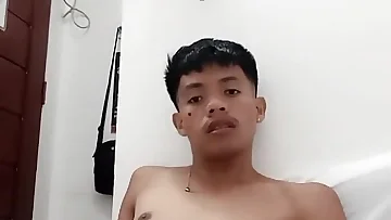 This Filipino twink desperately jerks his cock while begging for cum in his bedroom. He's so fucking horny that he shoots his load all over himself in this solo session.