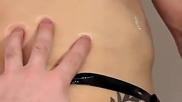 An oiled-up twink completely yields to some deep, sloppy cock worship. He gets his throat stretched and ass filled in this fetish-heavy scene.