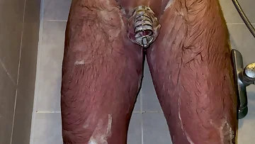 Locked in chastity during an entire shower session, the tension becomes unbearable. The eventual release is an absolutely explosive cumshot.