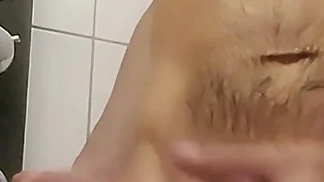 An amateur white dude is jerking his hard cock in the shower. The water makes everything slick as he works toward an explosive finish.