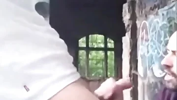 Caught jerking off in an abandoned building, he gets blown to completion. This public encounter turns into a couple's intense cumshot finale.