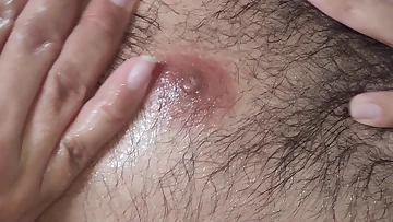 Slick oil glistens on his stomach as he strokes his cock methodically. The amateur solo action highlights every sensual movement under the lights.